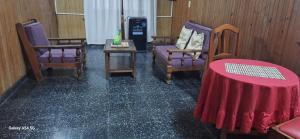 una habitación con tres sillas y una mesa con un mantel rojo en Hostal Orán, en San Ramón de la Nueva Orán