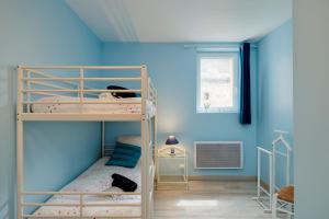 a bedroom with two bunk beds with blue walls at La Longere Chateau Vieux Mougnac in Petit-Palais-et-Cornemps