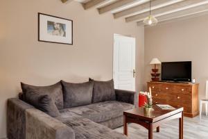a living room with a couch and a table at La Longere Chateau Vieux Mougnac in Petit-Palais-et-Cornemps