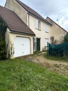 Saint-Denis-en-ValChez Dapia的房屋一侧的白色车库门