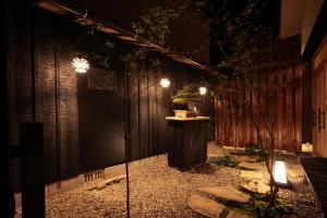 un jardín por la noche con luces en el lateral de un edificio en Sion Hotel, en Hatsukaichi