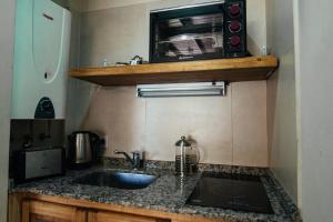 cocina con fregadero y microondas en un estante en Soles de Belén, en Carpintería