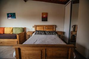 Un dormitorio con una cama de madera y un sofá. en Soles de Belén, en Carpintería 2 fotos más