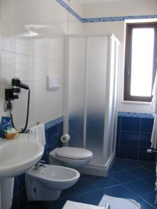 a blue and white bathroom with a toilet and a sink at Albergo Roma in San Ferdinando di Puglia