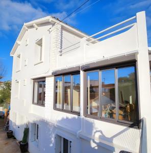 a white house with large windows at Villa Alekatele in La Tranche-sur-Mer