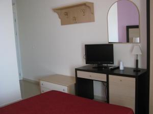 a bedroom with a desk with a television on it at Albergo Roma in San Ferdinando di Puglia