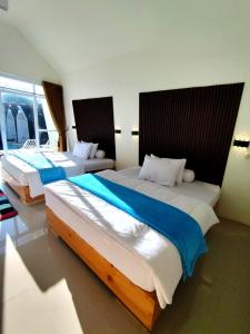 two beds in a hotel room with two bedsskirts at Dieng Hebat Villa & Glamping in Diyeng +33 photos
