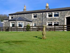 a vase in the grass in front of a house at Farmhouse in Dunragit