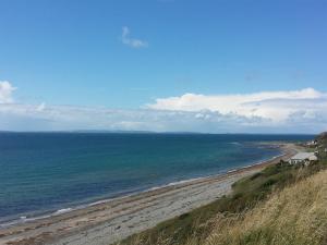 a view of a beach with the ocean at Farmhouse in Dunragit