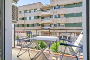 a table and chairs on a balcony with a building at Apartmento Calle Antonio Millón in Nerja