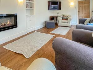 a living room with a couch and a fireplace at Barnhay Cottage in Totnes