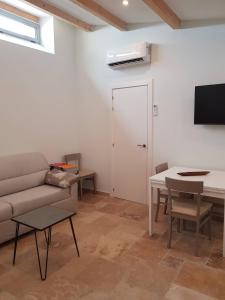 a living room with a couch and a table at Zenna - Arco Pronti in SantʼAgata di Puglia