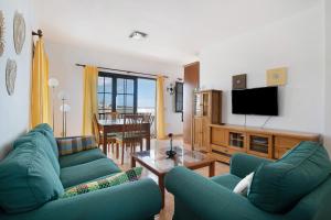 a living room with two blue couches and a television at Apartamento Fondeo in Tinajo