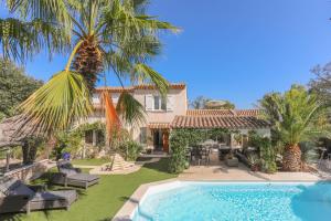ein Haus mit einer Palme und einem Pool in der Unterkunft Maison au Soleil d'Azur in Fréjus