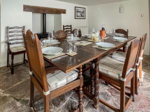 a dining room table with plates and glasses on it at Barnhay Cottage in Totnes