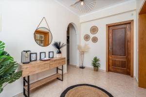 a hallway with a wooden door and a mirror at Casa Village in Senhora do Verde