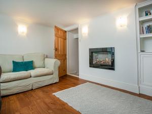 a living room with a couch and a fireplace at Barnhay Cottage in Totnes