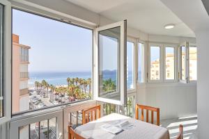 a dining room with a table and views of the ocean at Relájate frente al Mar A112 in Torrox Costa