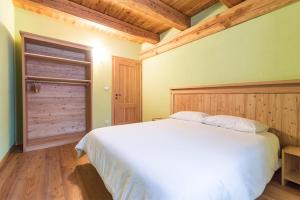 a bedroom with a white bed and a wooden ceiling at Civico 11 in Marmora