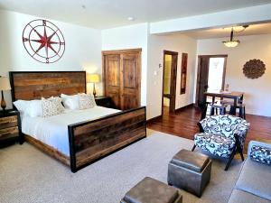 a bedroom with a large bed and a chair at Whitefish Downtown Suites in Outback Mobile Home Settlement
