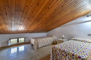 a bedroom with two beds and a wooden ceiling at Il Quadrifoglio 3 in Procchio