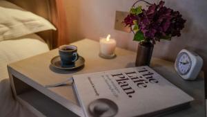 a book on a table with a cup of coffee and a candle at Host & Stay - Tin Bath in Aller +5 photos