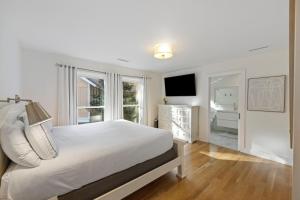 Un dormitorio blanco con una cama grande y una ventana. en LV19: 19 Lake Village, en Isle of Palms