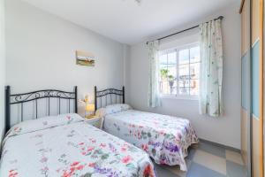 Dos camas en un dormitorio con ventana. en Apartamento Esbamar Vi, en Roquetas de Mar 17 fotos más