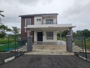 ein Haus mit einem Tor davor in der Unterkunft Villa Zuhaira homestay in Kangar