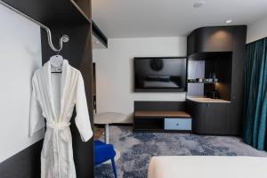 a hotel room with a white robe hanging on a wall at Bayside Geelong Hotel & Apartments, an Ascend Collection Hotel in Geelong