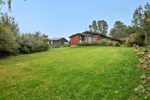 a large yard with a house in the background at LL258-Humble-Paradisvejen-11 in Østerskov