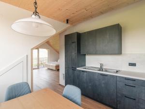 a kitchen with black cabinets and a wooden table at Haus Auer in Appiano sulla Strada del Vino +10 photos