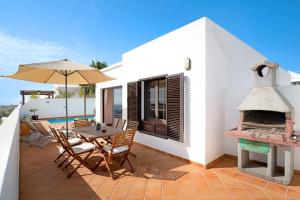 a patio with a table and chairs and an outdoor fireplace at Princesa Ico in Tías