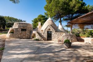 Un edificio de piedra con una puerta en un patio. en Trullo with Pool, en Ceglie Messapica