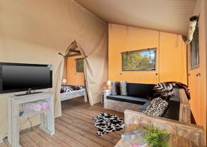 a living room with a couch and a flat screen tv at Celtic Escapes in Narberth