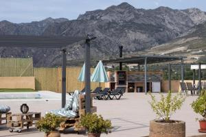 ein Pavillon mit Stühlen, einem Sonnenschirm und einem Pool in der Unterkunft Casa Rural Eralta in Dúrcal