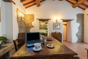 laptopa siedzącego na drewnianym stole w pokoju w obiekcie Appartamento La Loggetta w mieście Corgna