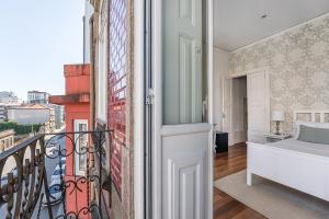 a room with a balcony with a bed and a window at GuestReady - Charming House Marquês in Porto +17 photos