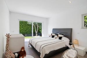 a bedroom with a bed and a giraffe and a window at Pine Lodge in Vilamoura +20 photos