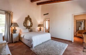 a bedroom with a white bed and a mirror at Villa Son Max in Port d’Andratx