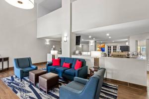 a living room with blue chairs and red pillows at Comfort Inn & Suites Surprise Near Sun City West in Surprise