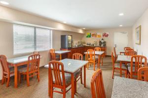 a restaurant with tables and chairs and a kitchen at Quality Inn & Suites Oceanside Near Camp Pendleton in Oceanside
