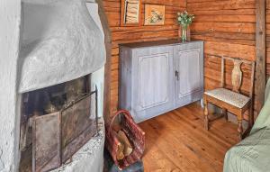 a living room with a fireplace and a chair at Gorgeous Home In Gränna With Lake View in Bjällebäck