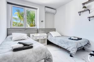 due letti in una stanza bianca con una finestra di Park Carpe Diem a Busot Altre 28 foto