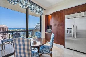 a kitchen with a table and a refrigerator at Elegant 2 Bedroom Condo with Ocean Views in West Palm Beach