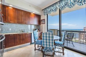 a kitchen with a table and chairs and a balcony at Elegant 2 Bedroom Condo with Ocean Views in West Palm Beach