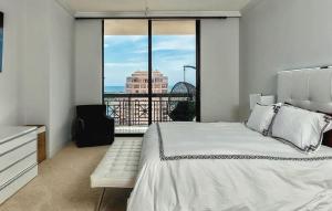 a bedroom with a white bed and a large window at Elegant 2 Bedroom Condo with Ocean Views in West Palm Beach