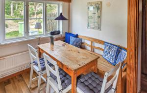 a dining room with a wooden table and chairs at Gorgeous Home In Gränna With Lake View in Bjällebäck