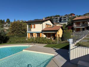 a villa with a swimming pool and a house at Villa La Dolce Vita in Costermano sul Garda