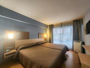 a hotel room with a bed and a large window at Hotel Faranda Alisas Santander, Ascend Hotel Collection in Santander
